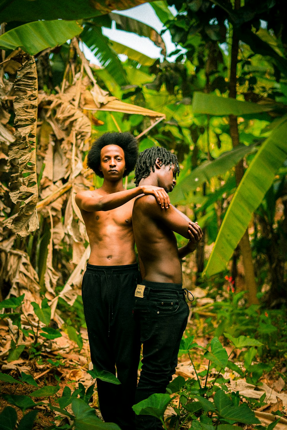 Un couple d’hommes debout l’un à côté de l’autre dans une forêt