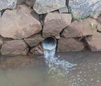 a large pipe is coming out of the water