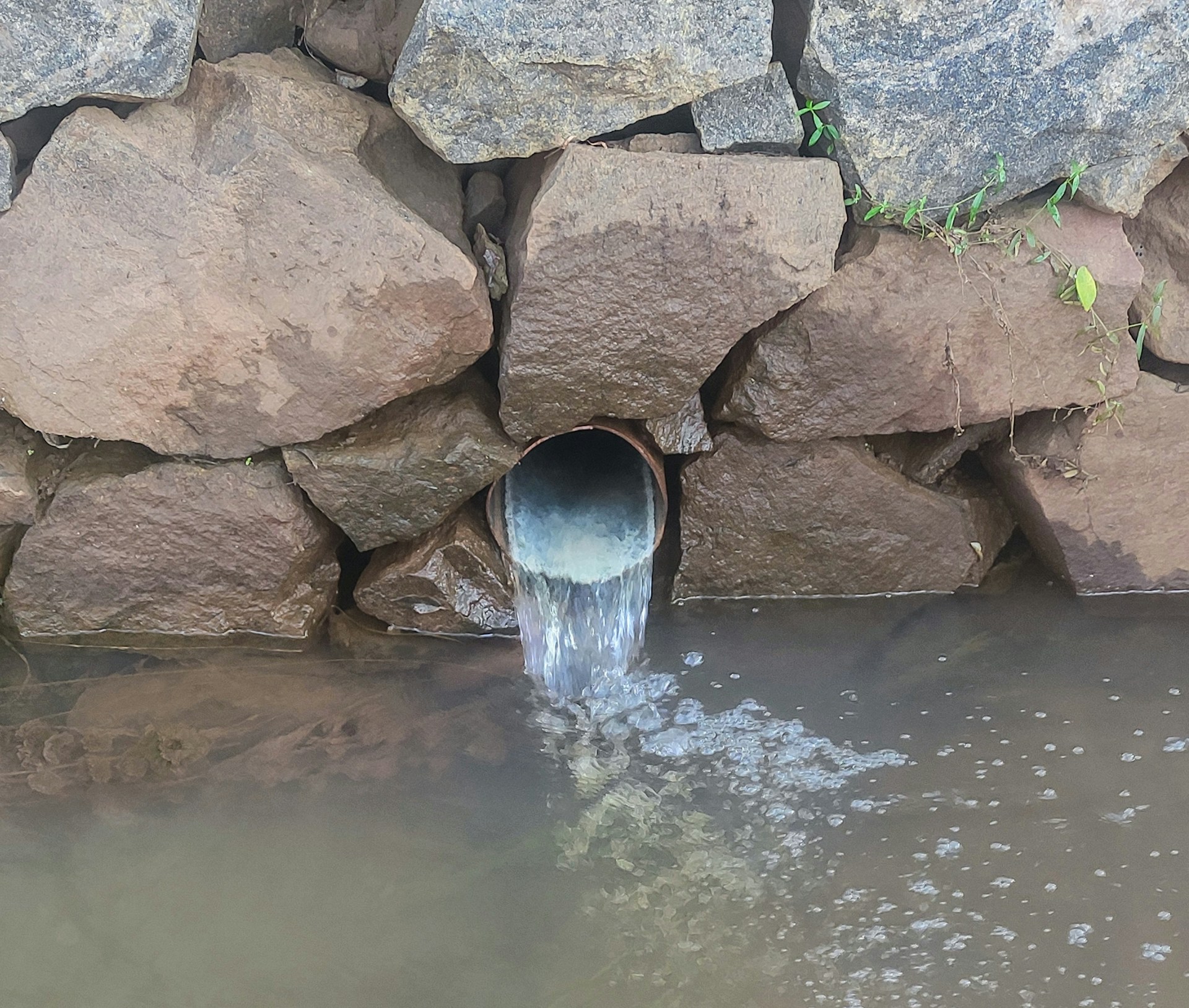 a large pipe is coming out of the water