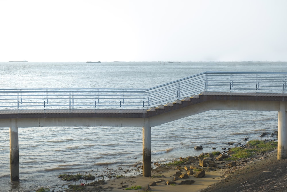 a bridge over a body of water with a boat in the distance