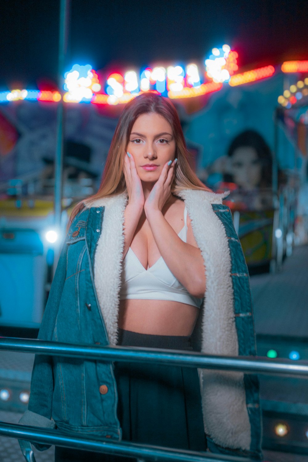 a woman standing in front of a carnival ride