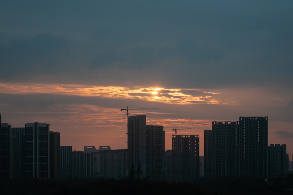 Die Sonne geht über einer Stadt mit hohen Gebäuden unter