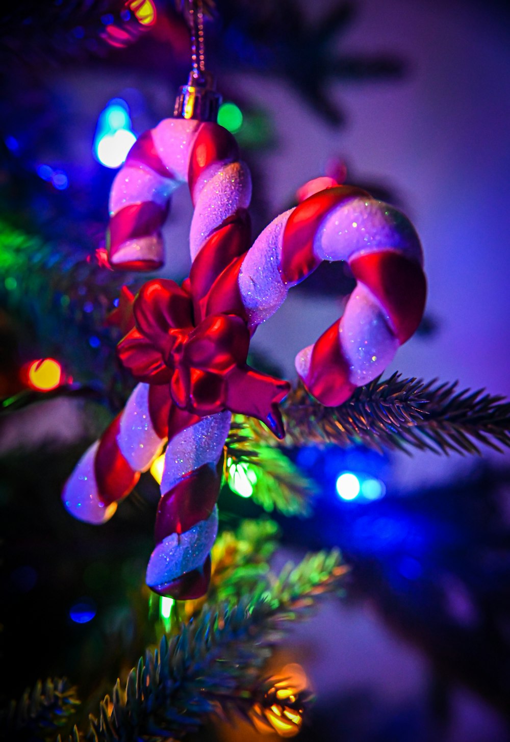 a candy cane ornament hanging from a christmas tree