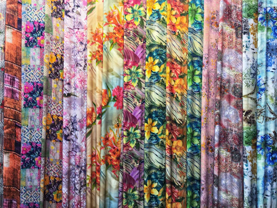 A close-up of vibrant, durable outdoor fabric rolls displayed in a bright textile workshop.