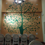 An elegant dining area highlighted by a large, colorful wall hanging decor piece from muralis.