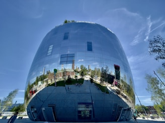 A sleek commercial building with green rooftop gardens and large glass windows reflecting the city skyline.