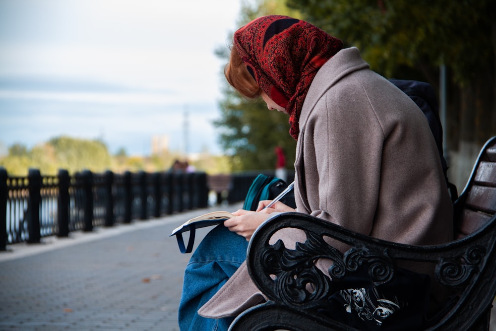 a woman sitting on a bench looking at her cell phone