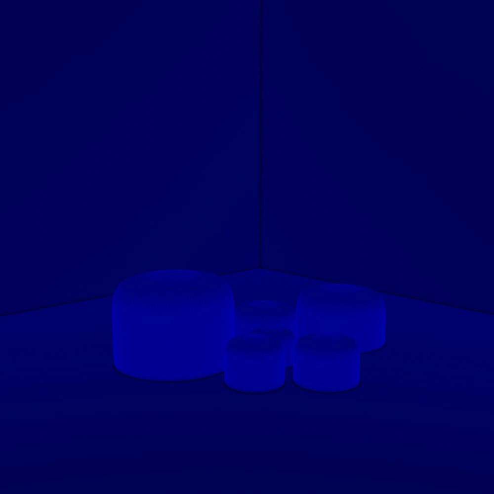 three blue stools in a dark room