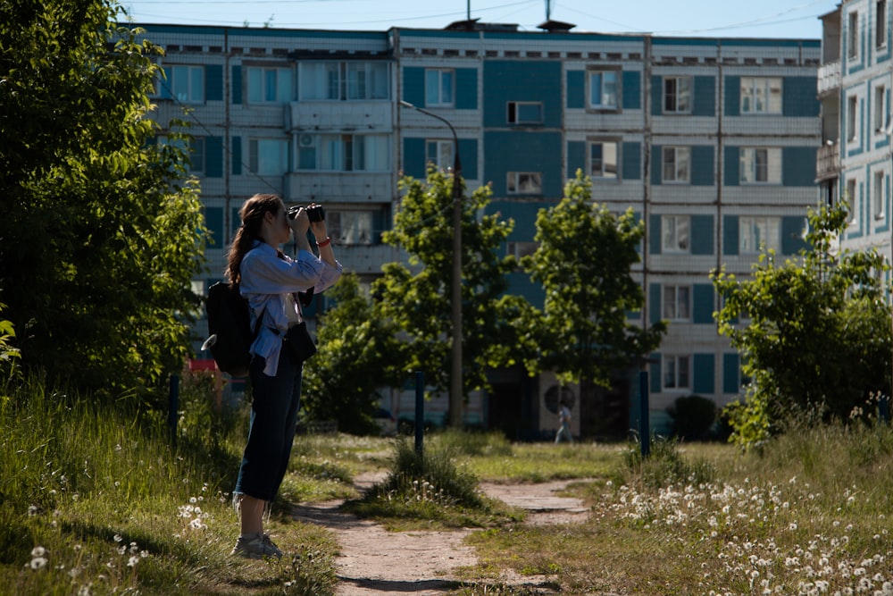 a woman taking a picture of a building with a camera