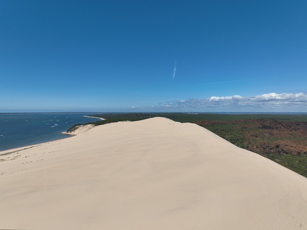 una spiaggia sabbiosa con uno specchio d'acqua in lontananza