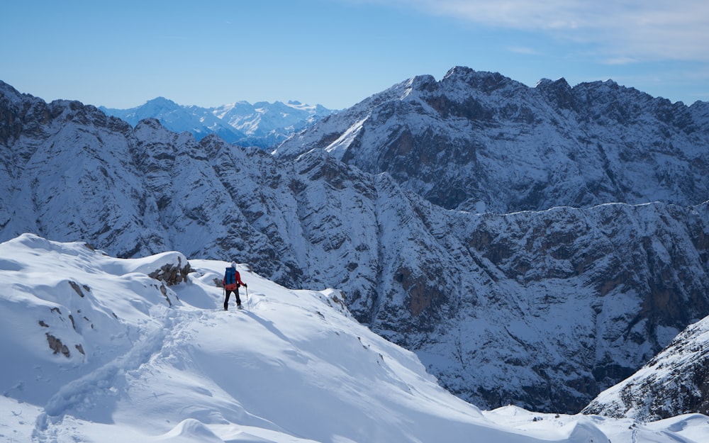 a man hiking up the side of a snow covered mountain