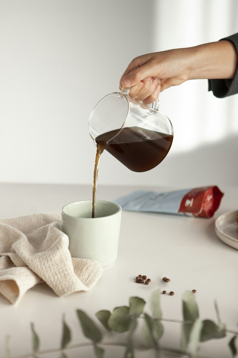 a person pouring coffee into a cup on a table