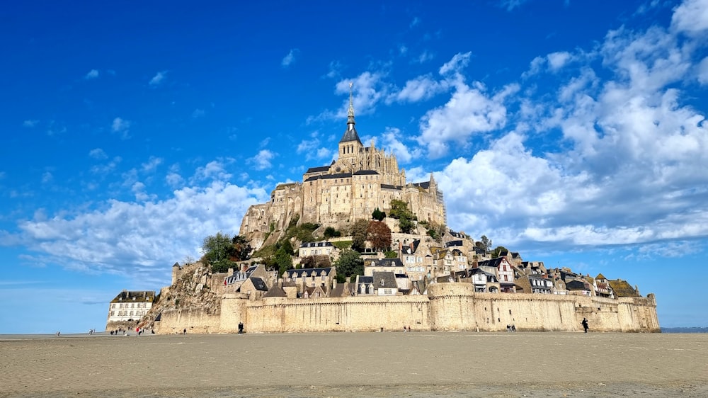 a very tall building sitting on top of a sandy beach