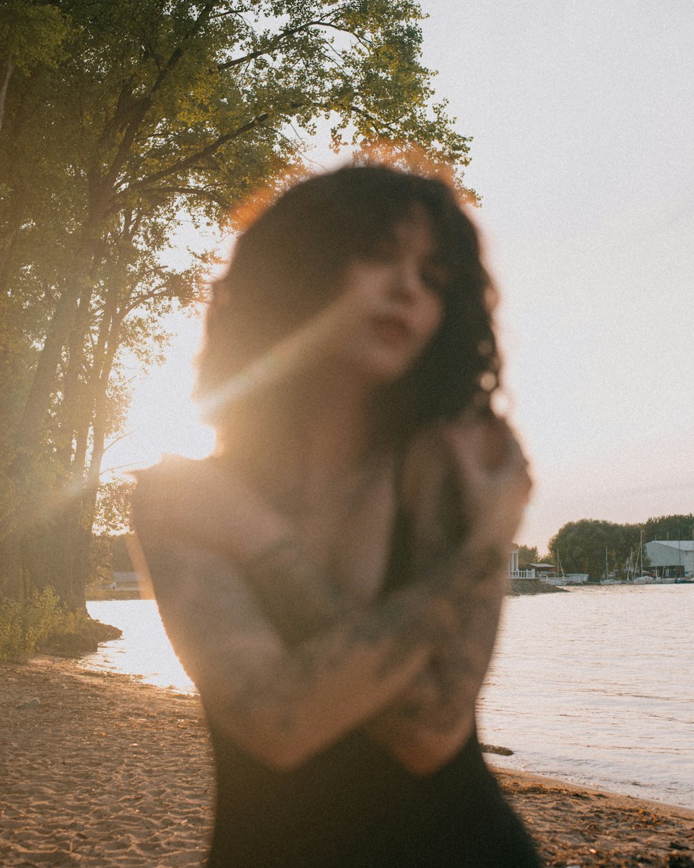 a woman standing on a beach next to a body of water