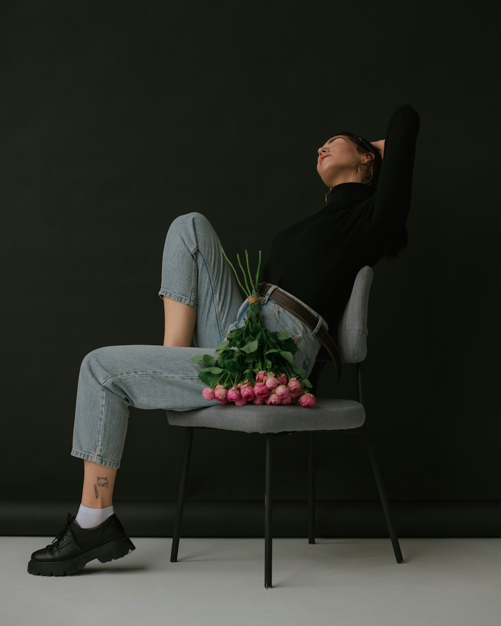 a woman sitting on a chair with a bunch of flowers