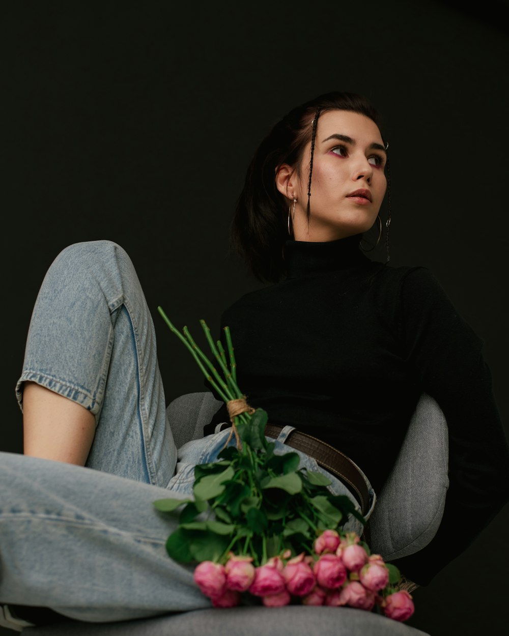 a woman sitting in a chair with a bunch of flowers