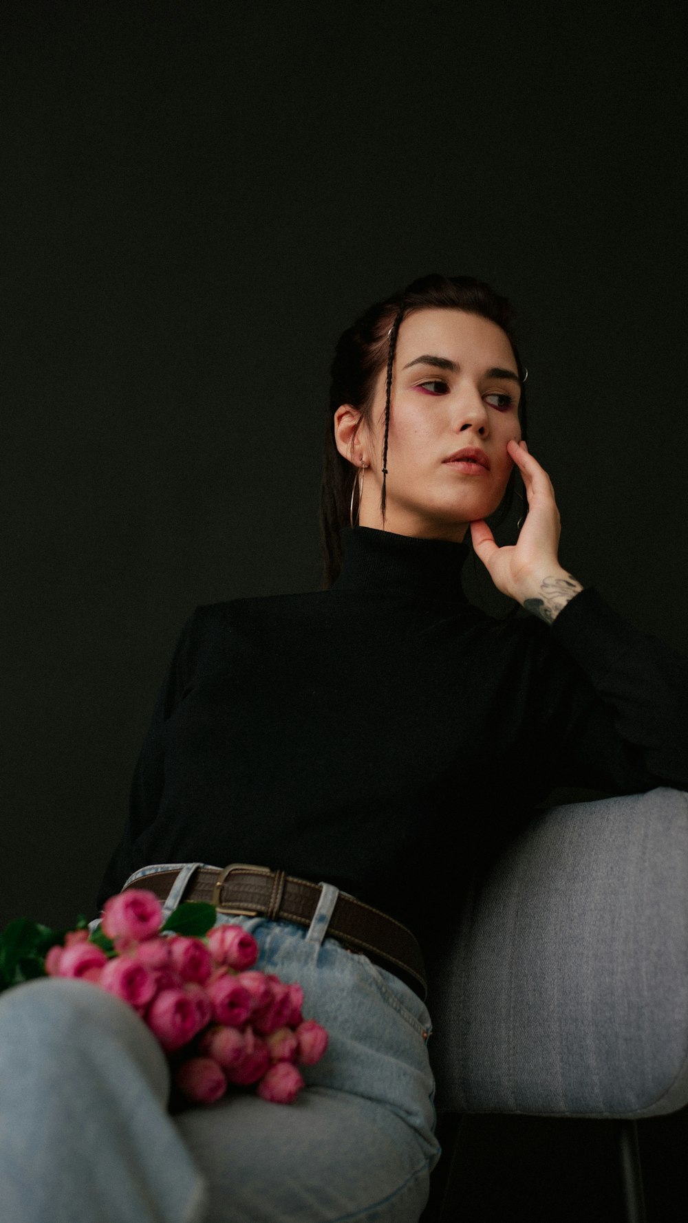 a woman sitting in a chair with a bouquet of flowers