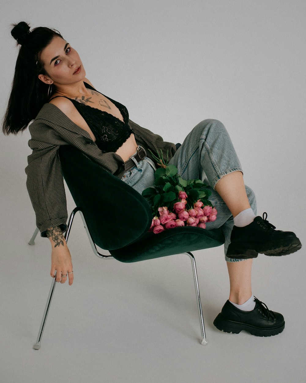 A woman sitting in a chair holding a bunch of flowers photo – Free
