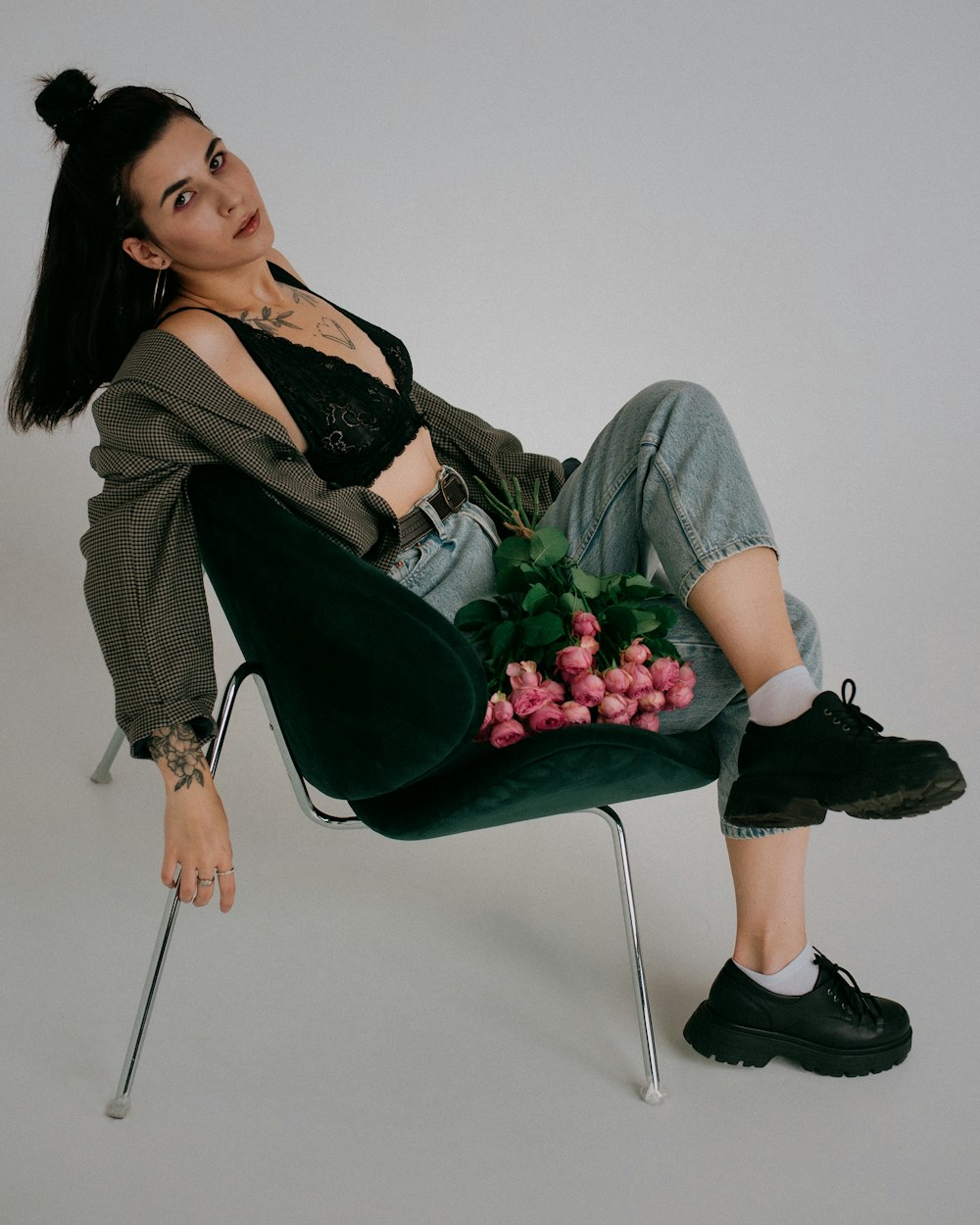 Una mujer sentada en una silla sosteniendo un ramo de flores