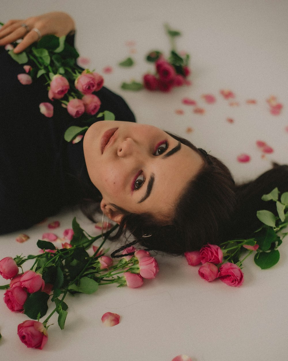 a woman laying on the ground surrounded by flowers