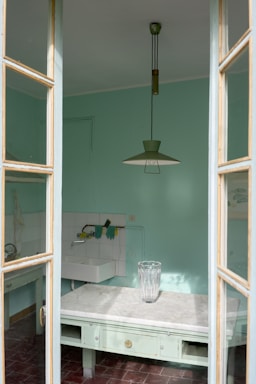 Modern kitchen with pastel green and white accents reflecting Italian heritage.