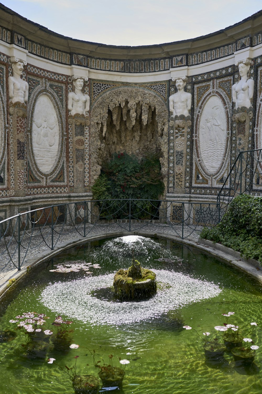 a fountain in the middle of a room with statues on the walls