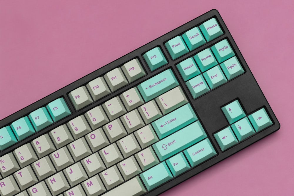 Un primer plano de un teclado sobre un fondo rosa