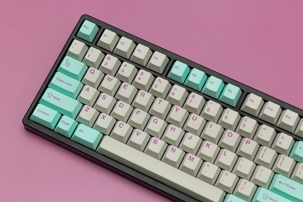 Un primer plano de un teclado sobre un fondo rosa