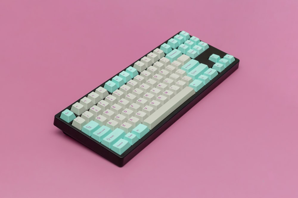 a computer keyboard sitting on top of a pink surface