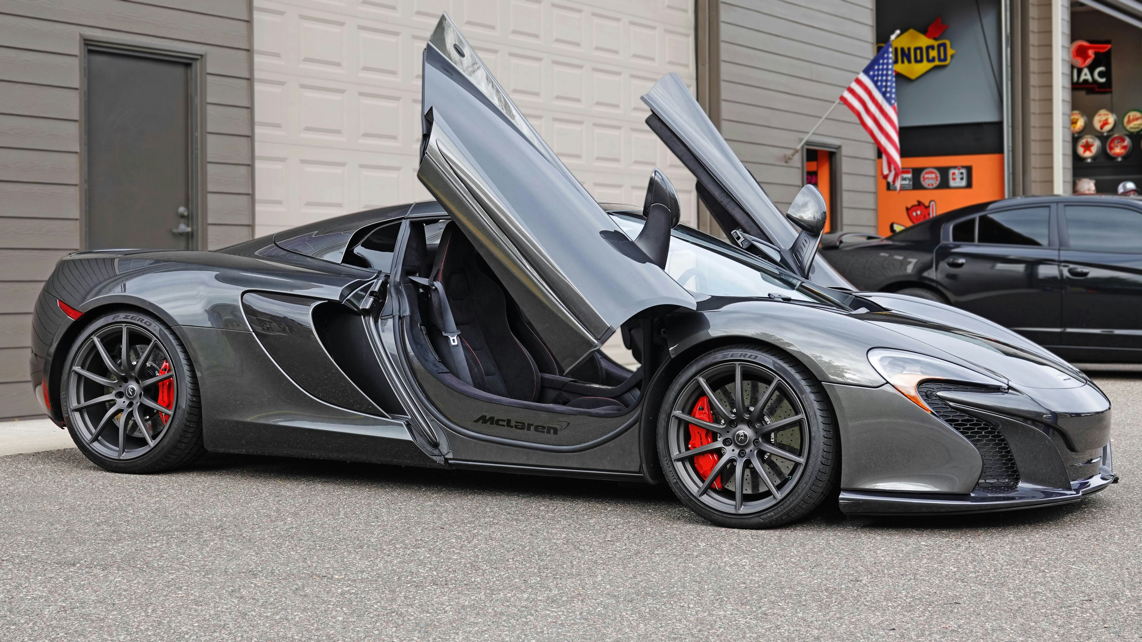a gray sports car parked in front of a garage