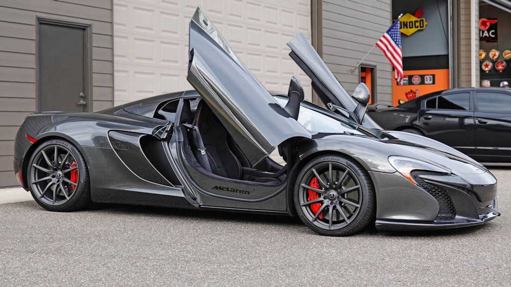 a gray sports car parked in front of a garage