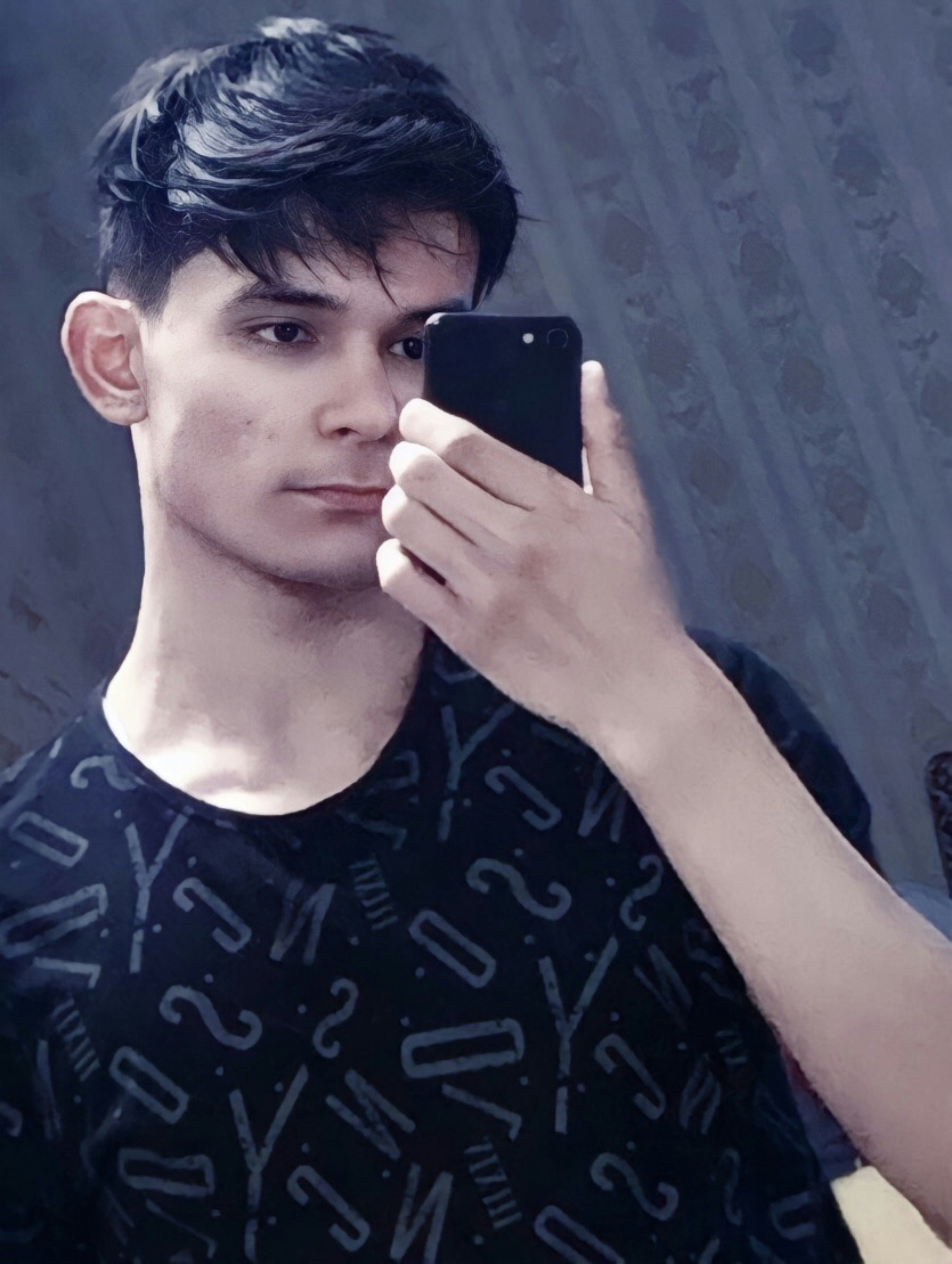 a young man holding a smart phone in his right hand