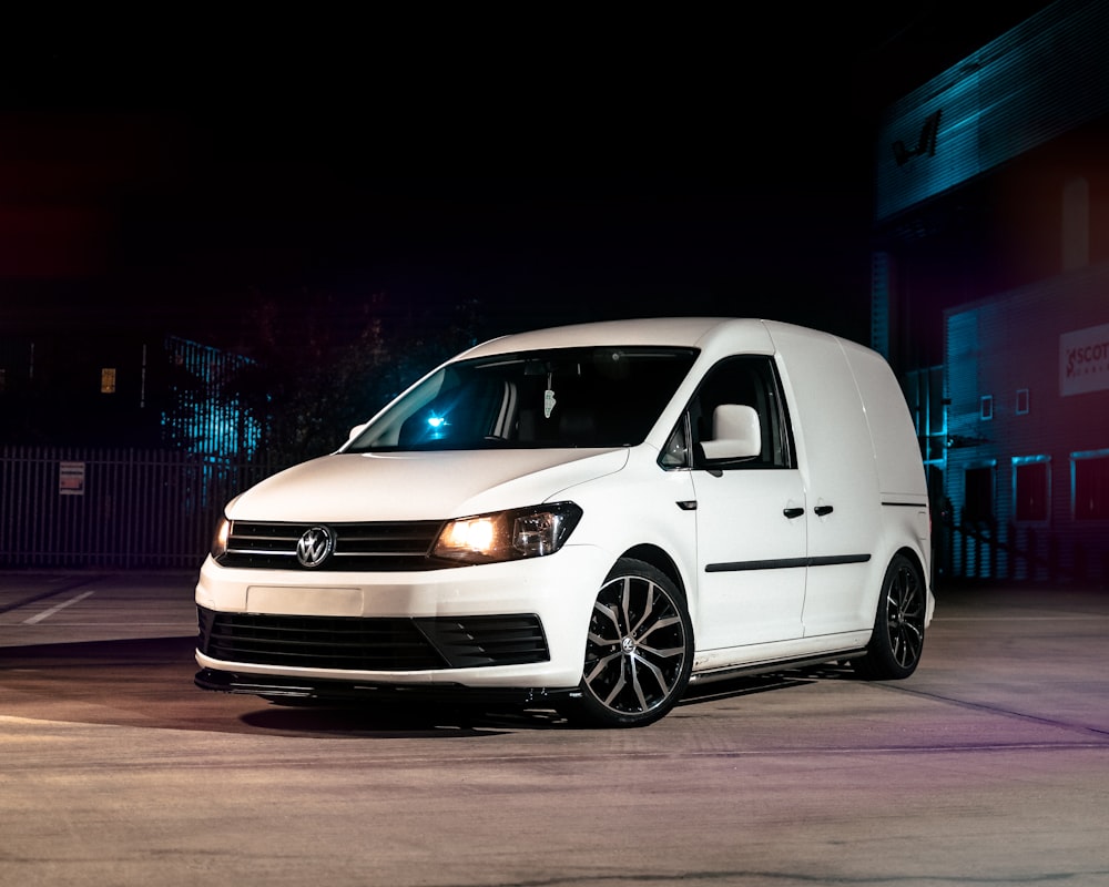 a white van parked in a parking lot at night