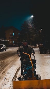 A quiet snow plow clearing a residential driveway early in the morning.
