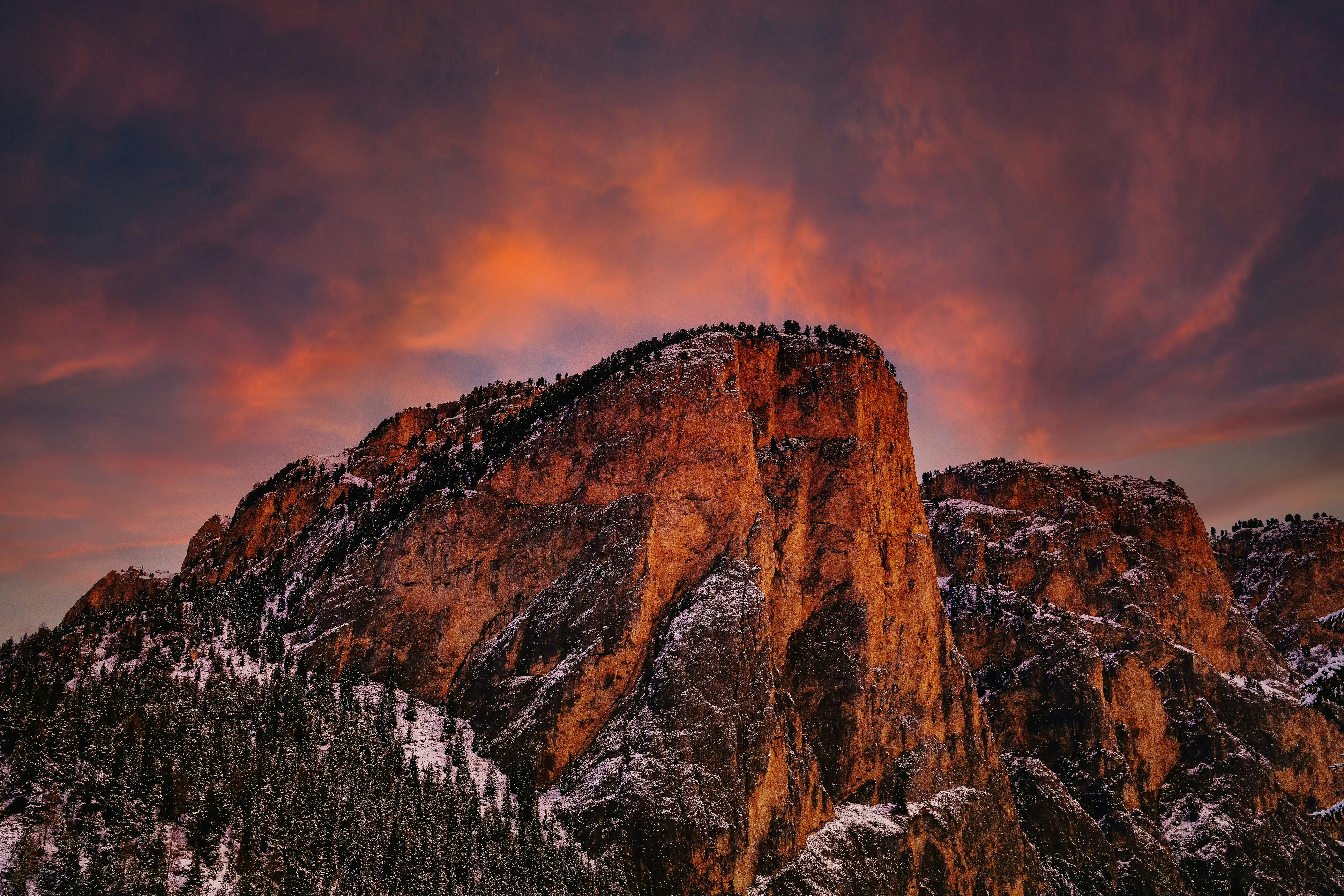 a mountain covered in snow under a cloudy sky