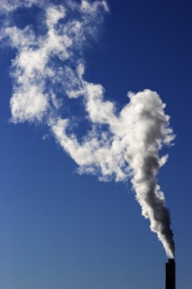 A cozy chimney with smoke gently rising against a clear blue sky.