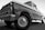 A classic vintage truck with a shiny surface and detailed front grille, viewed from a low angle emphasizing its robust build. The truck appears well-maintained with visible reflections on its body, highlighting the contours and craftsmanship of its era.