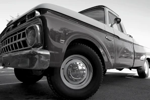 A before and after side-by-side of an old dusty truck transformed into a gleaming vehicle.