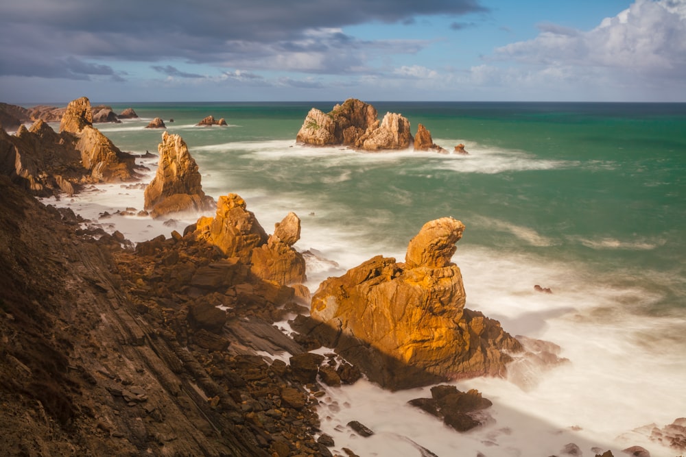 a view of the ocean with rocks in the foreground