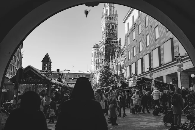 a group of people walking down a street next to tall buildings