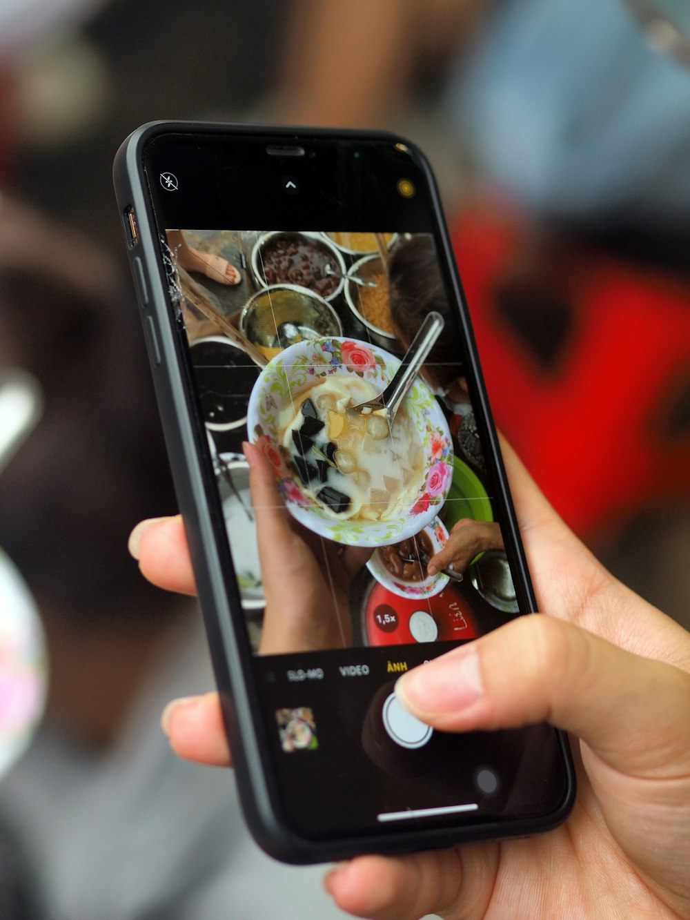 a person taking a picture of a bowl of food