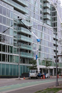 a crane is attached to a street light in front of a large building