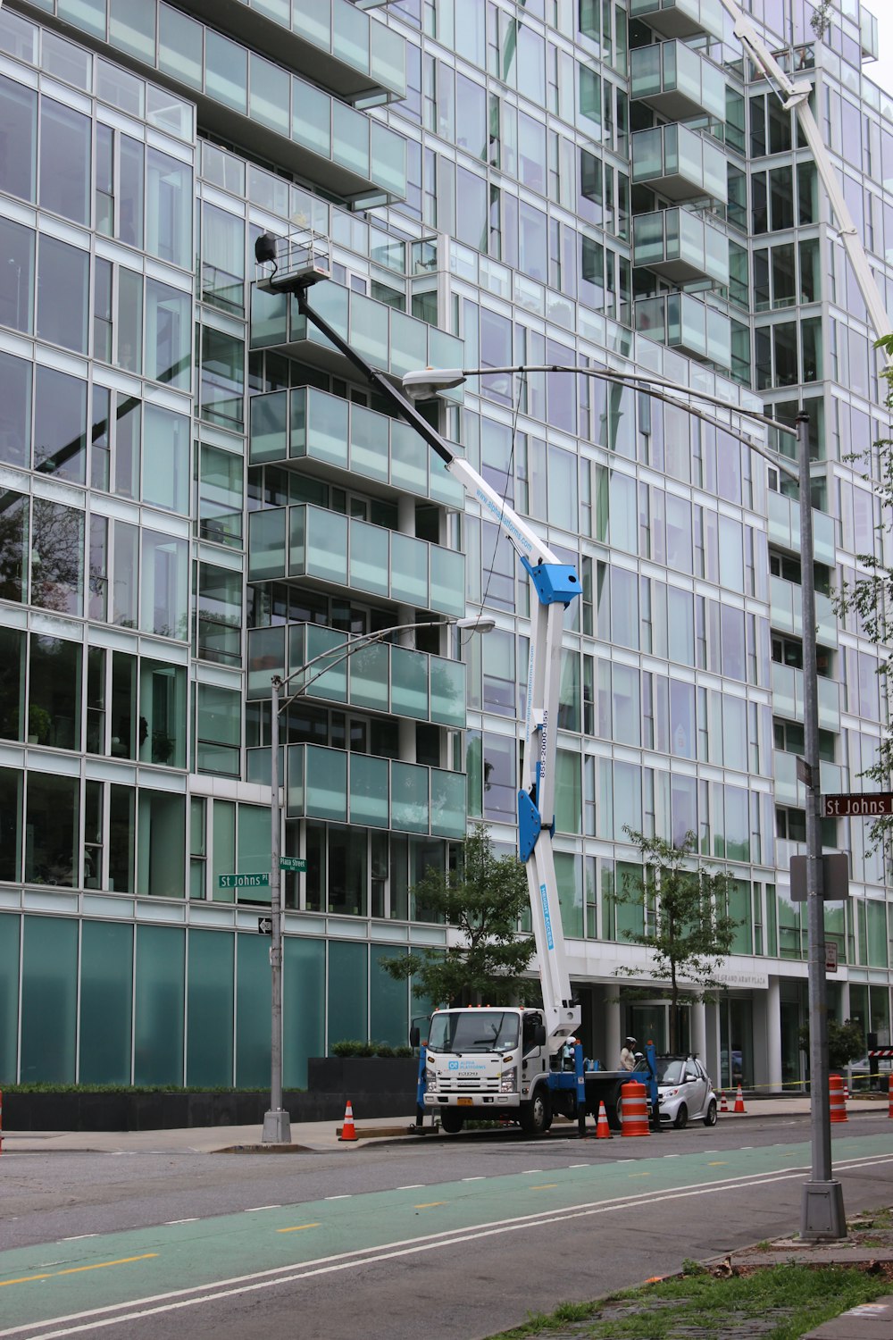 a crane is attached to a street light in front of a large building