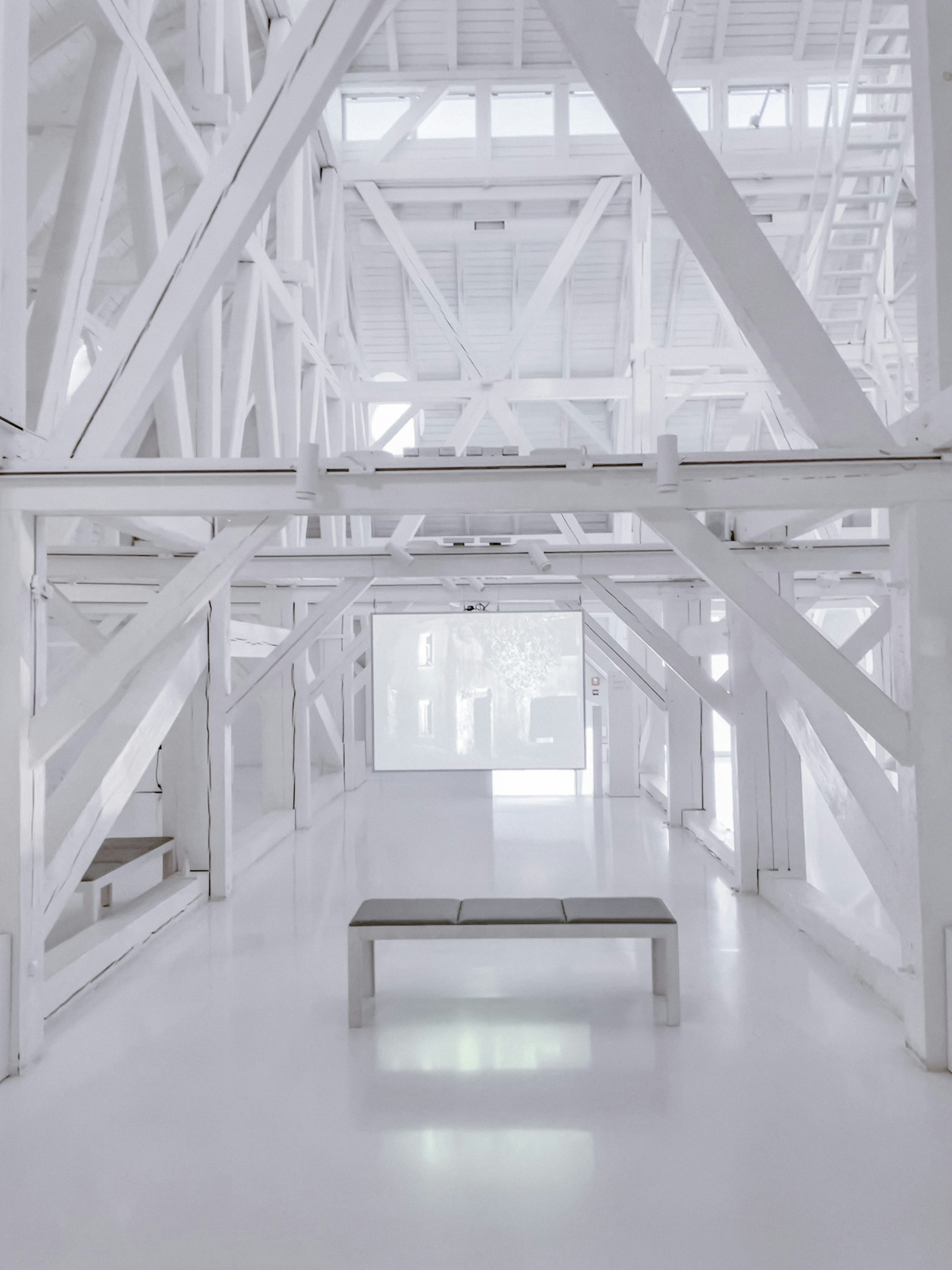 a white room with a bench in the middle of it