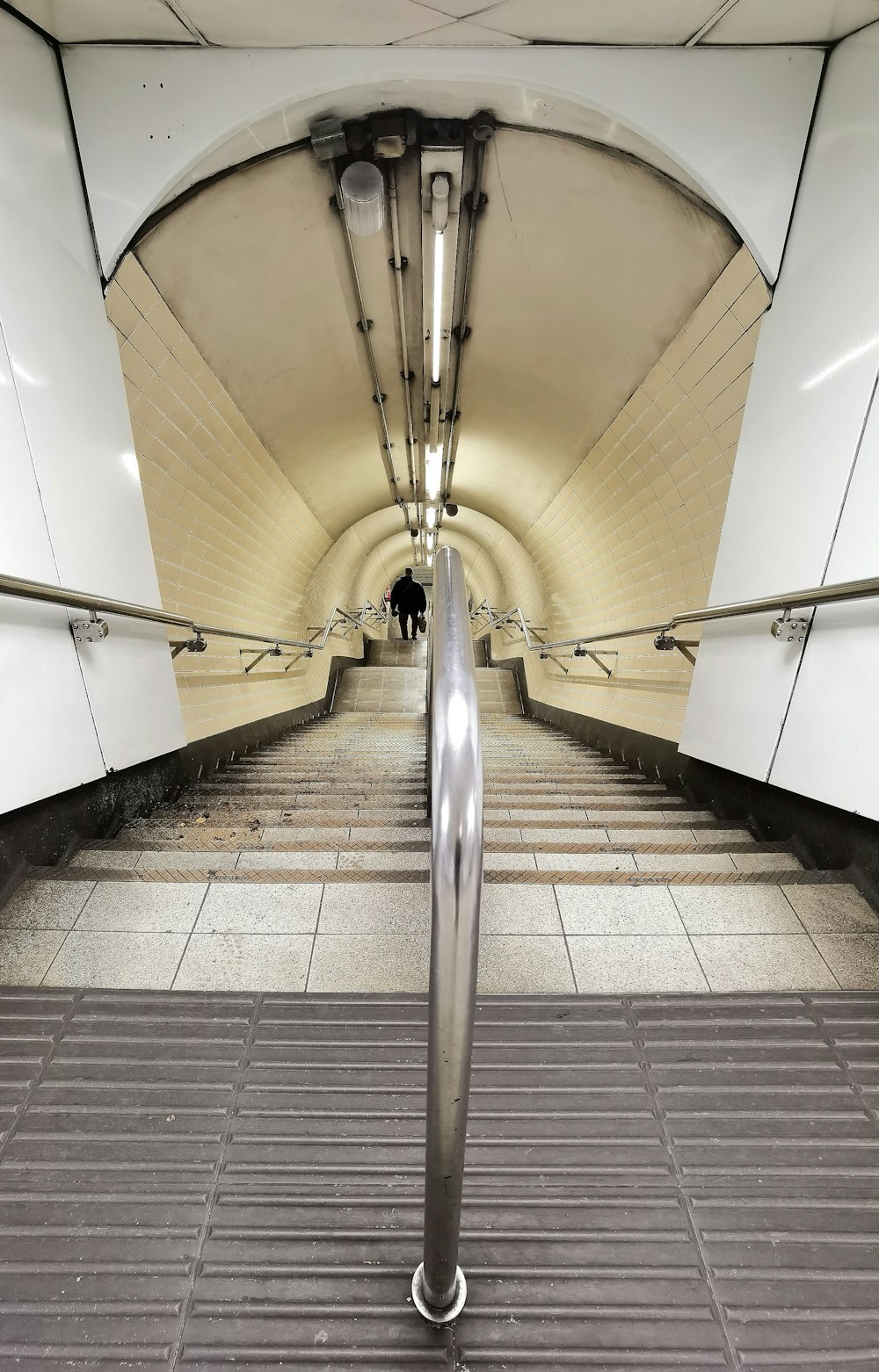 an escalator in a subway station with tiled flooring