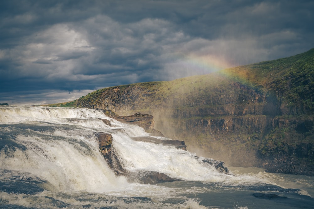 a waterfall with a rainbow in the background