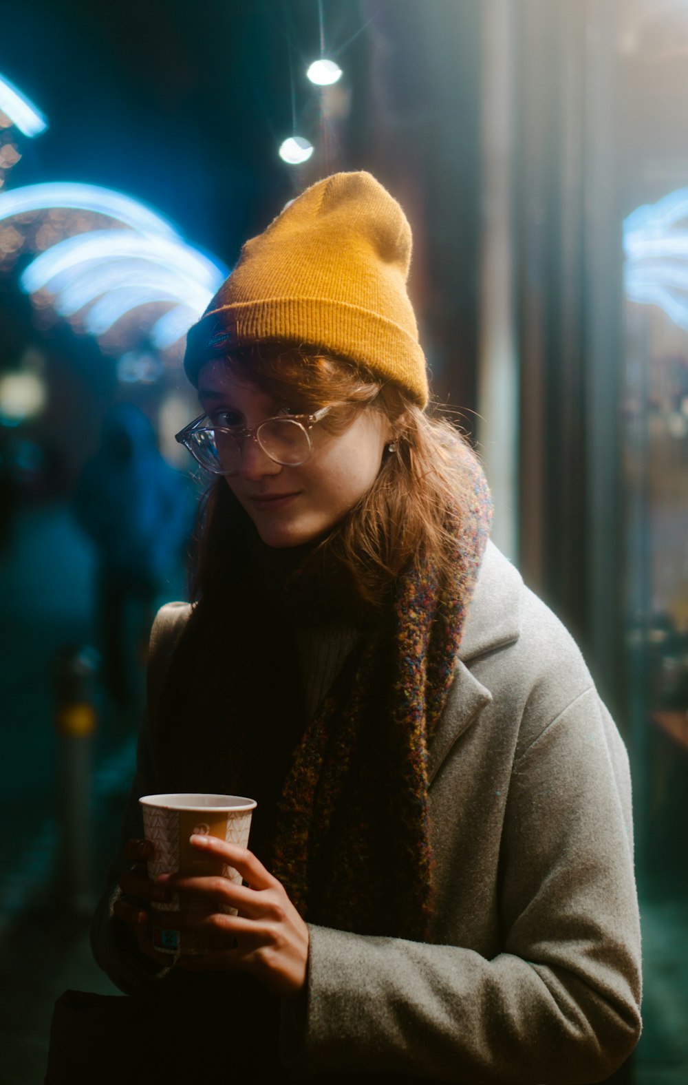 Foto Una mujer con un sombrero amarillo y una bufanda sosteniendo una taza  de café – Imagen Persona gratis en Unsplash