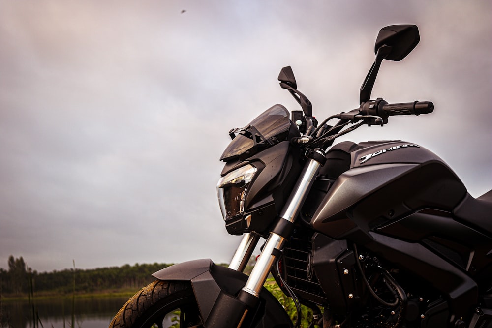 a motorcycle parked next to a body of water