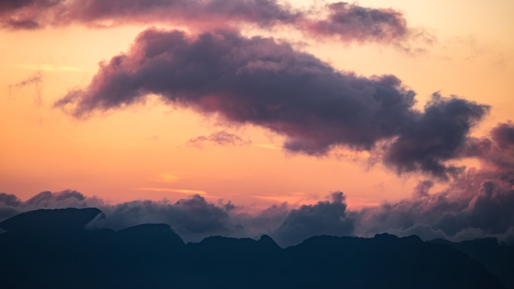 a plane flying in the sky with a sunset in the background