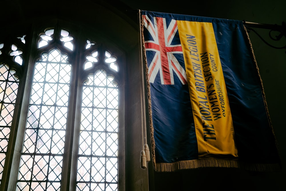 un drapeau suspendu sur le côté d’un bâtiment à côté d’une fenêtre